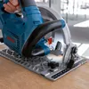 A close-up shot of a Bosch cordless circular saw being used on a wooden surface. Podgląd zdjęcia produktu