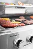 A close-up shot of a gas grill with food cooking on it. Podgląd zdjęcia produktu