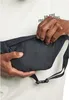 A person's hands are shown opening a zippered pocket on a black hip bag. Anteprima dell’immagine prodotto