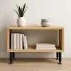 A wooden shelf unit with black legs, displaying books, bowls, and a plant. Náhled obrázku produktu