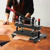 A person is using a manual stamping machine to cut leather on a wooden table. Náhled obrázku produktu