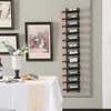 A wine rack mounted on a wall above a table set for a meal. Náhľad obrázku produktu