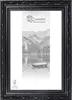 A black ornate picture frame with a landscape image and branding inside. Produktbild-Vorschau