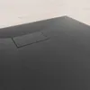 Close-up of a black shower tray with a drain cover. Produktbild-Vorschau
