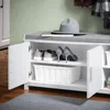 A white shoe bench with a gray cushioned seat, open doors revealing shoes and a storage bin, and a gray hat on top. Náhľad obrázku produktu