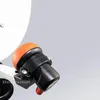 A close-up view of a satellite dish LNB (Low-Noise Block downconverter) with an orange protective cap and black housing, mounted on a white arm. The LNB has adjustment markings. Produktbild-Vorschau