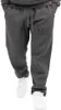 A person wearing grey sweatpants with a black logo on the left leg and white sneakers. Produktbild-Vorschau