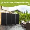 An outdoor patio scene with a black, four-panel room divider set up on a paved patio. Furniture and greenery are visible in the background. Anteprima dell’immagine prodotto