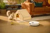 A white robot vacuum cleaner is cleaning a wooden floor next to a cat and a cat house. Náhľad obrázku produktu