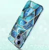 A phone case with a geometric marble design in shades of blue and teal, with gold accents, is shown at an angle against a light blue and green gradient background with bokeh effects. Podgląd zdjęcia produktu