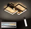 A modern ceiling light fixture with two interlocking square frames, illuminated with warm white light. A remote control is shown in the lower right corner, and a graphic displays dimming and color temperature options. Produktbild-Vorschau