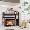 A kitchen counter with a microwave oven on a shelf, along with various kitchen items. Produktbild-Vorschau