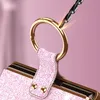 A close-up shot of a pink glittery phone case with a gold ring holder, being drilled into by a drill bit, creating sparks. Produktbild-Vorschau
