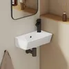 A modern white ceramic wall-mounted sink with a black faucet in a bathroom setting. Anteprima dell’immagine prodotto