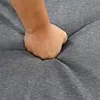 A hand is pressing into a gray fabric surface, indicating softness and cushioning. Produktbild-Vorschau