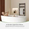 A woman relaxing in a bathtub with steam rising, next to a towel warmer. Produktbild-Vorschau