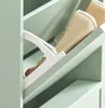 Close-up of a light green shoe cabinet with an open drawer revealing beige shoes and a white shoe holder. Produktbild-Vorschau
