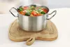 A pot of steaming vegetables sits on a wooden trivet. Podgląd zdjęcia produktu