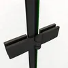 A close-up view of a black shower hinge and frame, with a green glass panel visible behind it, set against a white brick wall. Produktbild-Vorschau
