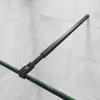 A close-up view of a black aluminum frame shower wall with a flexible stabilizer, mounted against a tiled wall. Produktbild-Vorschau