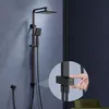 A black shower system is mounted on a blue wall, with a close-up inset showing a hand interacting with a control. Podgląd zdjęcia produktu