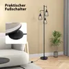 A floor lamp with three conical shades is shown in a living room setting next to a sofa and a potted plant. A close-up inset shows a foot operating the lamp's foot switch. Produktbild-Vorschau