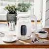 A white electric kettle with a digital display is shown on a wooden countertop, next to a cup of coffee and coffee beans. Produktbild-Vorschau