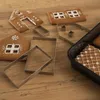 Gingerbread house pieces and metal cookie cutters on a wooden surface. Voir les images du produit