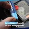 A hand inserts an AA battery into a device. Produktbild-Vorschau