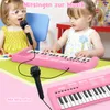 Two young children are playing with a pink toy keyboard and microphones. Produktbild-Vorschau