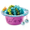 A decorated pottery bowl filled with beads and jewelry, with dice on the rim. Produktbild-Vorschau
