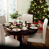 A Christmas-themed tea set laid out on a dining table in front of a decorated Christmas tree. Podgląd zdjęcia produktu