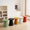 A row of colorful stools are placed on a wooden floor in front of a white shelf and a window. Anteprima dell’immagine prodotto