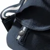 A close-up view of a navy blue canvas backpack, focusing on the strap and closure mechanism. Voir les images du produit