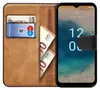 A book-style phone case with a phone inside, showing cards and banknotes in the case. Podgląd zdjęcia produktu