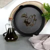 A cast iron pan with oil in it, a bottle of oil, and a plant. Náhled obrázku produktu