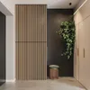 A modern hallway with wood slat wall panels, a hanging plant, and built-in cabinets. Produktbild-Vorschau