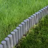 A row of dark gray garden edging posts is placed along a grassy lawn. Produktbild-Vorschau