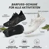 Zwei Barfußschuhe, einer schwarz und einer weiß mit rosa Akzenten, mit Feature-Callouts auf Deutsch Produktbild-Vorschau