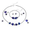 A jewelry set including a necklace and bracelet with various charms and beads, laid out on a white background. Produktbild-Vorschau