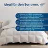 A white down comforter is shown on a bed with text overlays describing its features. Voir les images du produit
