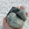 Grüngraue Steine auf einer Handfläche zur Größendarstellung Produktbild-Vorschau
