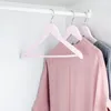 Pink and gray clothes hang on pink hangers on a white closet rod. Produktbild-Vorschau