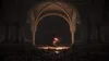 A lone figure holding a torch stands in a dark, cavernous hall with stone arches and pillars, surrounded by a mass of dark, organic material. Produktbild-Vorschau