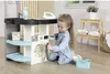 A young girl is playing with a toy laundry set, mimicking household chores. Produktbild-Vorschau