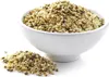 A white bowl filled with hemp seeds, with a small pile of hemp seeds in front of it, on a white background. Produktbild-Vorschau