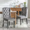 Two dining chairs are placed in a dining room setting, with a wooden sideboard in the background. Podgląd zdjęcia produktu
