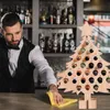 A bartender is cleaning a bar counter next to a wooden Christmas tree-shaped advent calendar filled with mini bottles. Podgląd zdjęcia produktu