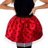 A person wearing a red and black polka dot tutu skirt. Produktbild-Vorschau