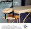 A beige massage table with a headrest and armrest attachment, set against a light gray background. Produktbild-Vorschau